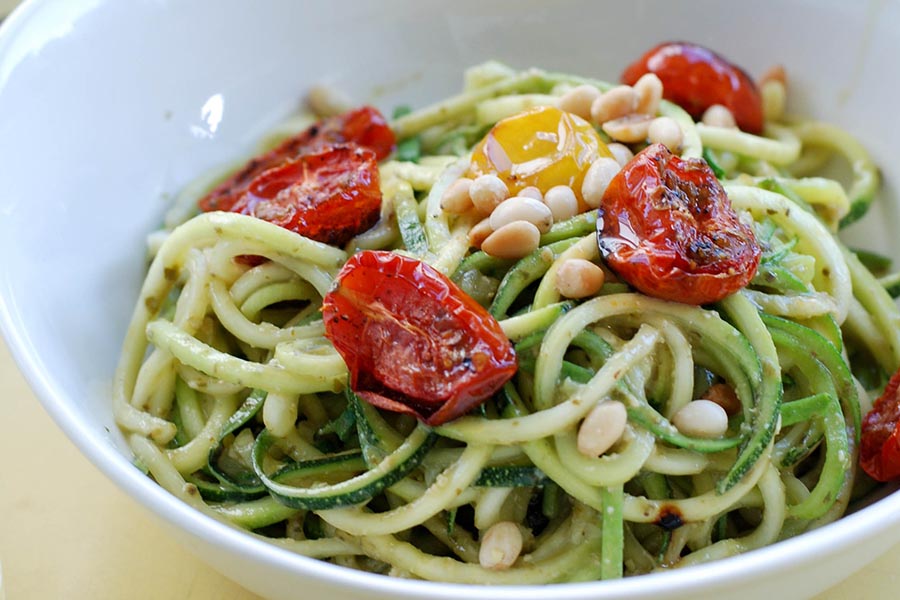 Zucchini-Nudeln mit Pesto-Verde, gebackenen Cocktail-Tomaten und Zedernüssen Zucchini-Nudeln mit Pesto-Verde, gebackenen Cocktail-Tomaten und Zedernüssen