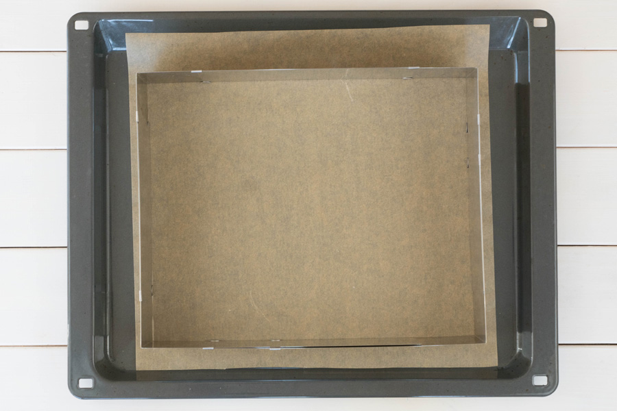 5. Schritt: Einen Backrahmen auf 35x25 cm auslegen, auf einem Backpapier auf das Backblech legen und am unteren Rand mit etwas Öl bestreichen.