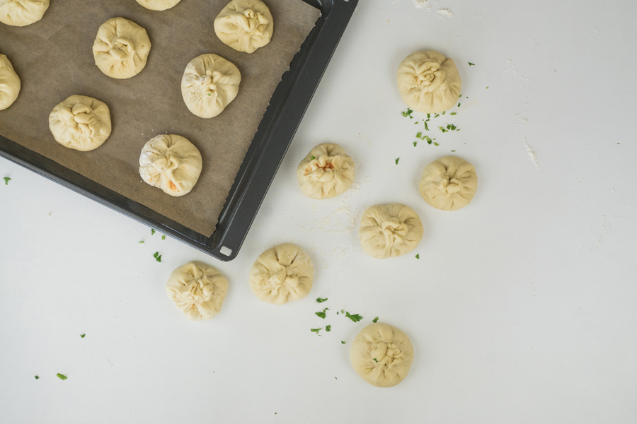 14. Die Teigtaschen mit etwas Wasser besprenkeln und in einer geölten Schale auf dem Grill ausbacken. Alternativ auf ein mit Backpapier ausgelegtes Backblech legen, mit etwas Wasser besprenkeln und im Backofen bei 190°C Ober-/Unterhitze etwa 20 - 25 Minuten backen.