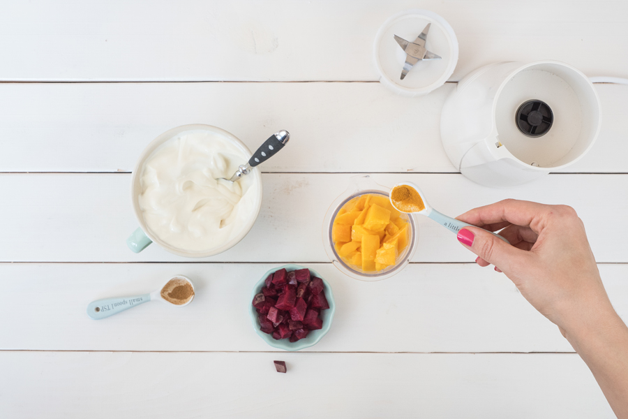 Nun werden die zwei Farben des Cheesecakes gezaubert. Dazu zunächst die Mangowürfel mit 2 EL Quark und etwas Kurkuma in den Mixer geben und fein pürieren.