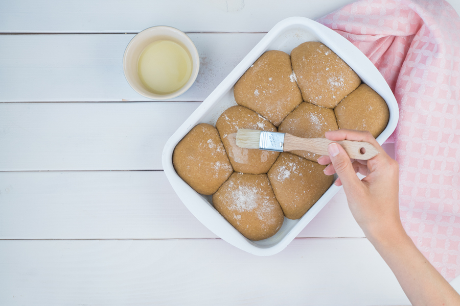 Zugedeckt an einem warmen Ort 30 Minuten gehen lassen, bis sich das Volumen deutlich vergrößert hat. Die Teiglinge mit etwas Pflanzendrink bestreichen und bei 180°C Ober-/Unterhitze 25 Minuten backen. Aus dem Ofen nehmen und in der Form 20-30 Minuten abkühlen lassen. 