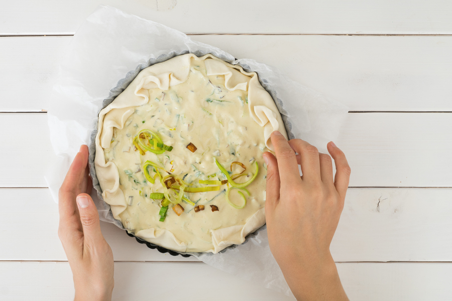 Den Blätterteigrand mit den Fingern leicht kräuseln und über die Füllung legen. Bei 200°C im Ofen 25 bis 30 Minuten backen. 